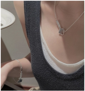 Detailed macro view of S925 silver key pendant necklace and matching bracelet set