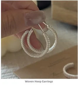 Macro detail of S925 sterling silver woven hoop earrings with intricate spiral texture