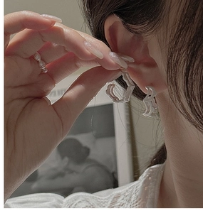 Close-up of S925 sterling silver earrings and ring with vintage wavy texture