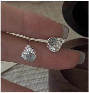 Close-up of S925 silver earrings with irregular texture and light blue gemstone detail
