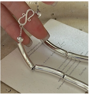 Detailed view of silver thick tube chain necklace with S-hook clasp and ball accents