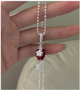 Detail of S925 silver necklace featuring a red enamel strawberry pendant with flower