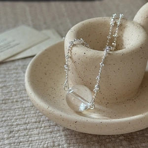S925 sterling silver necklace with clear white crystal pendant on a ceramic background