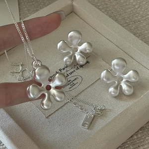S925 sterling silver matte hollow flower necklace and earrings set on jewelry tray