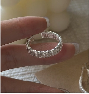 Gros plan sur la texture du fil tissé et la finition argentée vintage de la bague en argent S925