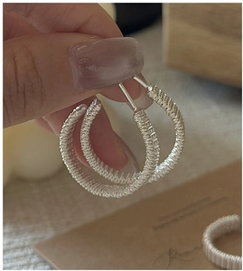 Close-up of S925 sterling silver hoop earrings with intricate handmade wire wrap detail