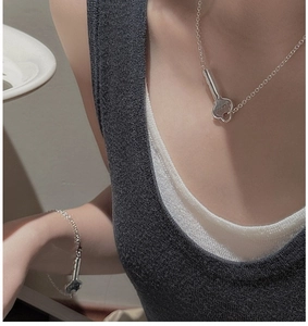 Close-up of polished S925 sterling silver key pendant necklace and bracelet set on a model