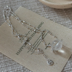 Minimalist S925 sterling silver necklace with clear crystal pendant on linen background