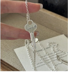 Detailed macro view of S925 sterling silver key pendant featuring Love Me engraving