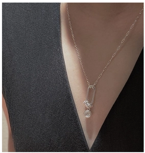 Macro detail of S925 sterling silver necklace featuring oval ring and sparkling crystal pendant