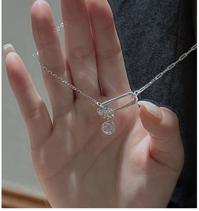 Macro detail of S925 sterling silver chain with circular rings and round zircon pendant