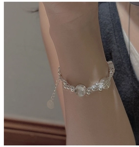 Detail view of a S925 sterling silver beaded bracelet with translucent charms on a wrist