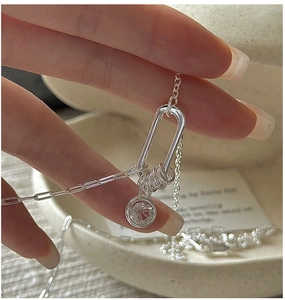 Macro detail of S925 sterling silver chain with U-shaped pendant and clear zircon stone