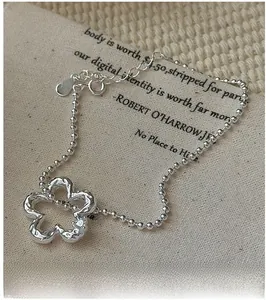 Dettaglio del bracciale in argento S925 con ciondolo a fiore traforato e materico