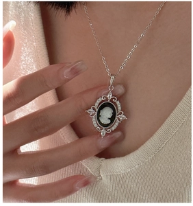 Detailed view of an oval cameo portrait pendant with sparkling cubic zirconia on a silver chain