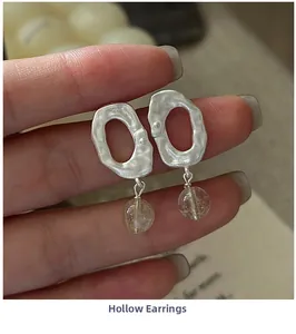 Macro view of S925 silver hollow earrings featuring transparent crystal beads and textures