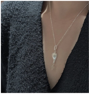 Dettaglio della collana in argento S925 con pendente in metallo fluido e cristallo su nero