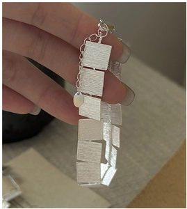 Close-up of brushed silver S925 bracelet featuring rectangular links and lobster clasp