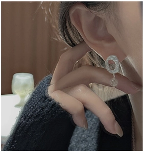 Close-up of matte S925 sterling silver earring with a clear crystal bead on a model