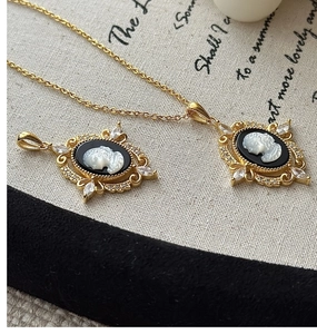 Close-up of vintage cameo pendant with oval silhouette and sparkling zircon details