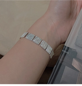 Macro view of minimalist S925 sterling silver chain bracelet with brushed metal texture