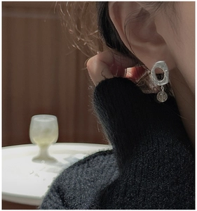 Detail view of a matte S925 sterling silver irregular hoop earring with a translucent pendant