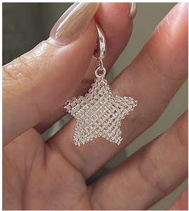 Close-up of S925 sterling silver star pendant with 3D mesh texture and polished ring