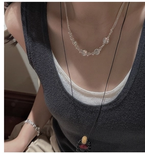 Detail of layered S925 sterling silver necklaces with colorful beads and minimalist design