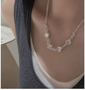 Detailed close-up of S925 sterling silver layered necklace with clear beaded pendants