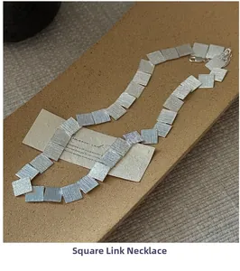 Close-up of a brushed S925 sterling silver square plate necklace on a ceramic prop