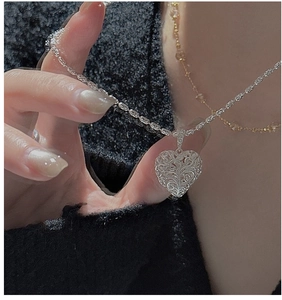 Close-up of S925 sterling silver heart pendant with vintage hollow texture and chain