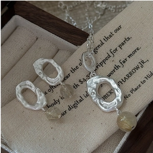 Detail showing irregular hammered texture on S925 silver earrings and rutilated quartz beads