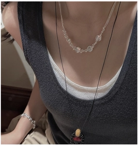 Detail of bohemian layered S925 silver necklaces with clear beads and ethnic pendant