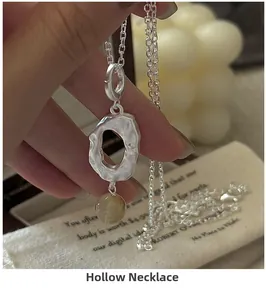 Detailed view of silver hollow pendant necklace with translucent yellow crystal bead