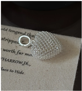 Macro shot of 925 silver hollow mesh heart pendant with intricate beaded texture