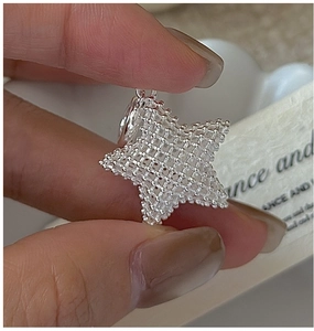 Macro shot of 3D mesh texture and beaded star pendant in S925 sterling silver