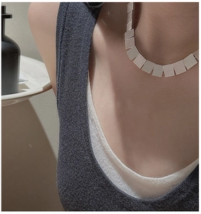 Macro view showing brushed texture on silver square pendant necklace for women