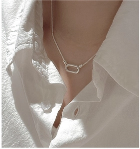 Gros plan du collier en argent S925 avec maille filet et fermoir ovale sur le cou