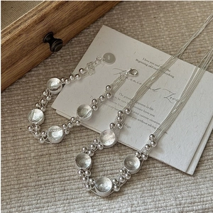 Detail of S925 sterling silver multilayer necklace and bracelet with vintage round charms