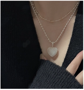Close-up of double-layered S925 silver necklace with 3D hollow mesh heart pendant