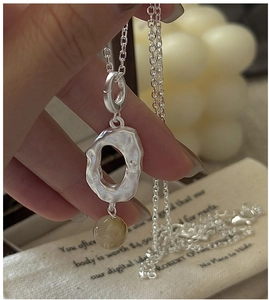 Detailed close-up of S925 silver necklace with yellow crystal and lava texture pendant