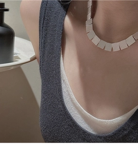 Close-up of S925 sterling silver necklace featuring brushed square metal pieces on neck