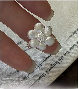 Close-up of S925 sterling silver flower ring with brushed petals and center zircon stone