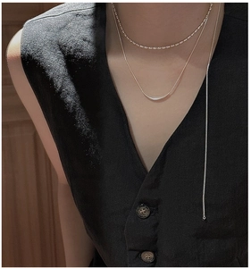 Gros plan du collier sourire en argent S925 avec chaîne serpent sur col en V noir