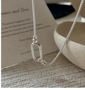 Vue macro d'un pendentif carré en argent S925 sur une chaîne à maillons fins