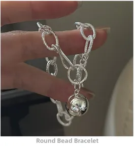 Detail of a 925 sterling silver chunky chain bracelet with a large polished ball pendant