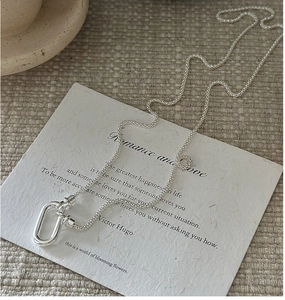 Détail macro de la chaîne en argent S925 tressé avec pendentif boucle ovale minimaliste