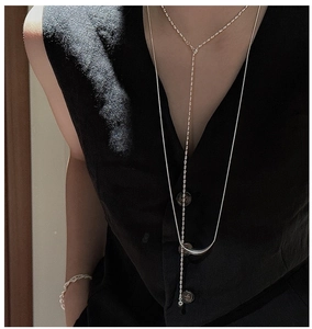 Détail du collier sourire en argent S925 et chaîne serpent sur mannequin en noir