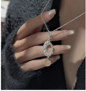 Detail of S925 silver necklace with hammered oval pendant and yellow crystal bead
