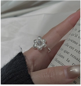 Macro detail of S925 sterling silver flower ring with matte texture and zircon